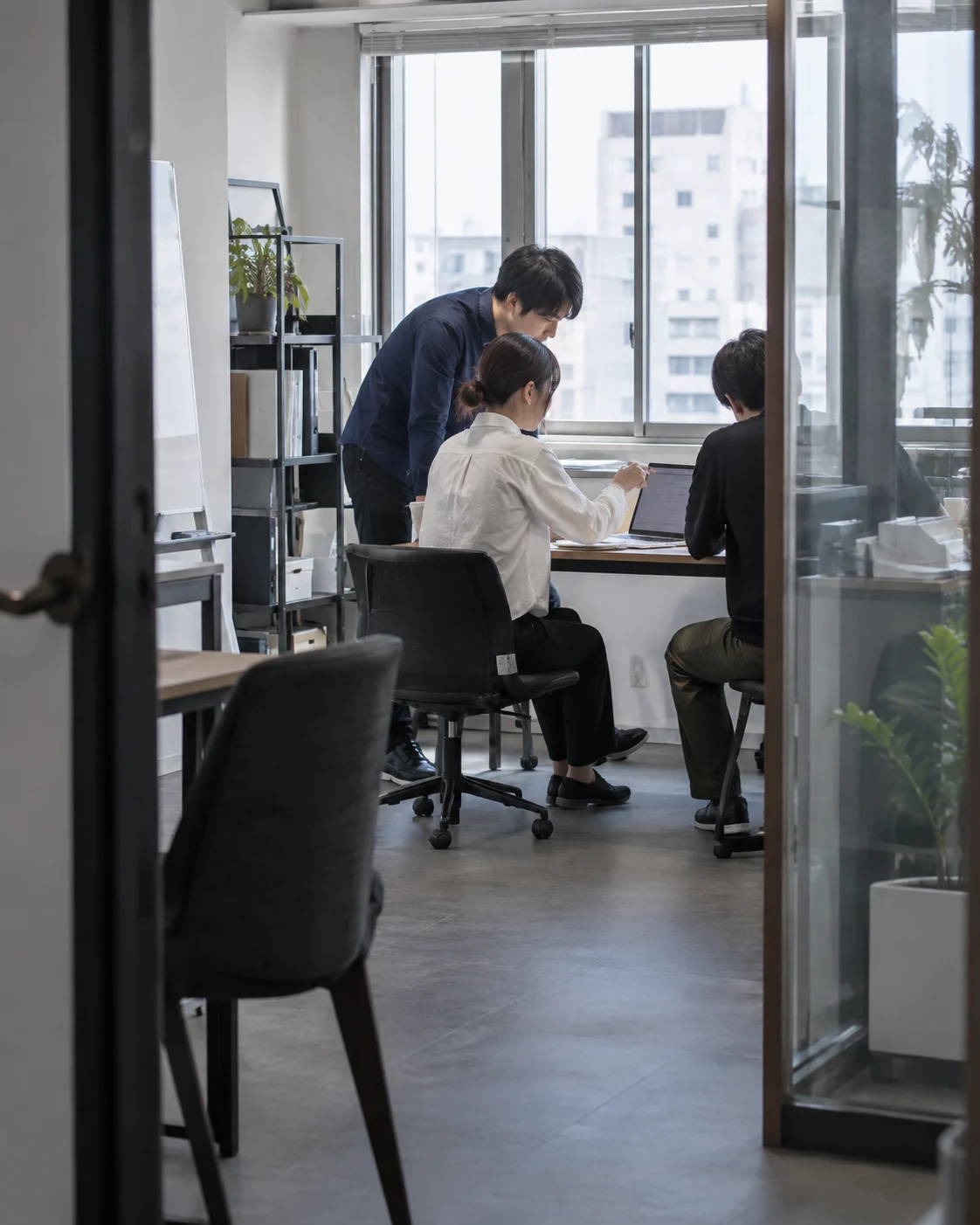 小さな仕事場で改善案を確かめるチームのイメージ